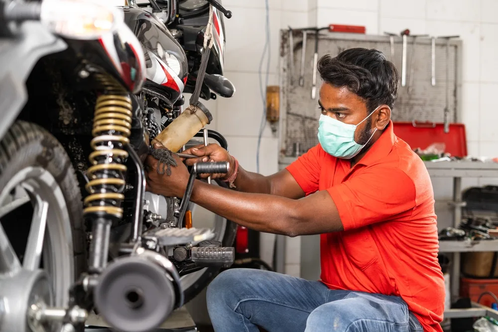 Professional doorstep bike service in Pune - Expert mechanic servicing motorcycle at customer's location with tools and spare parts